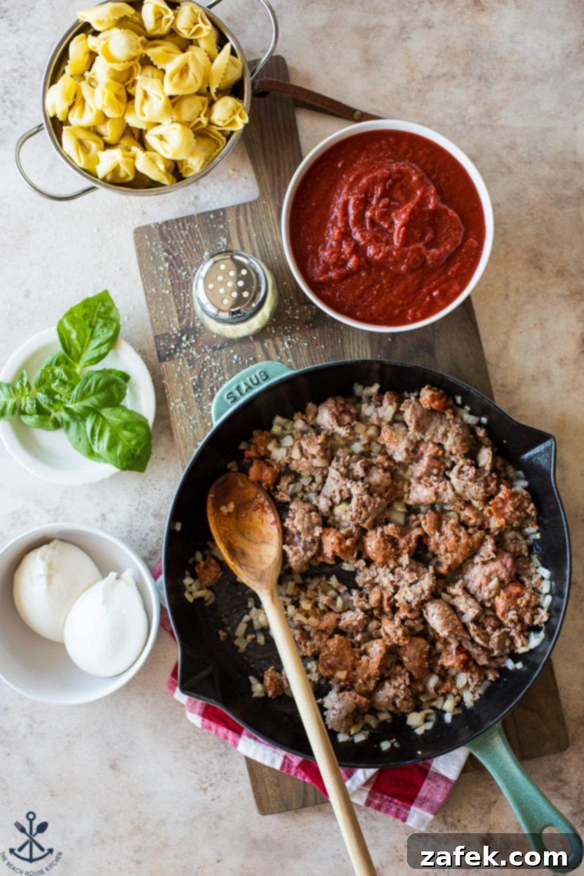 Cheesy Italian Sausage Tortellini Casserole 3 Close-up of the Italian sausage and onions browning in a skillet, an essential step for building flavor in the tortellini bake.