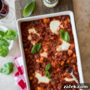Cheesy Italian Sausage Tortellini Casserole 7 Italian Sausage Tortellini Bake in a white baking dish, garnished with fresh basil, ready to serve.