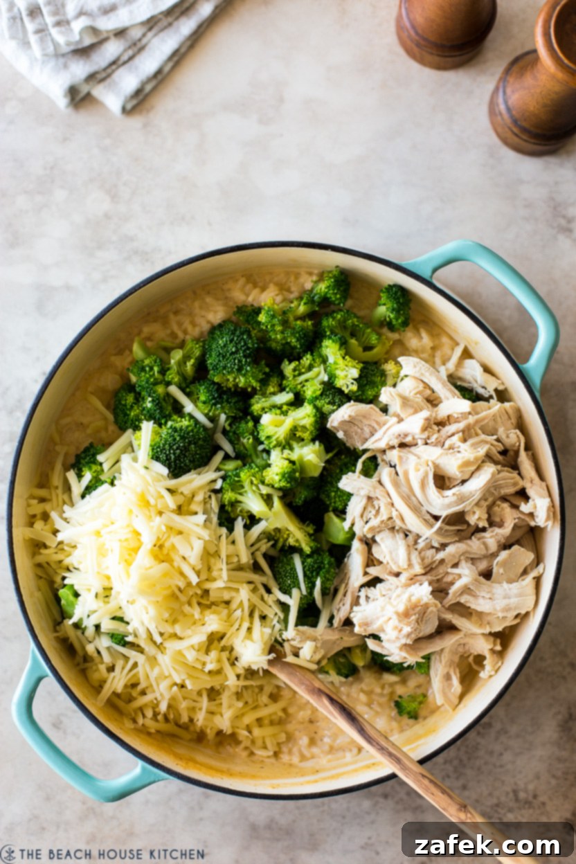 Creamy Chicken and Broccoli Rice Casserole 7 Overhead photo of a round baking dish filled with rice, shredded chicken, broccoli and cheese