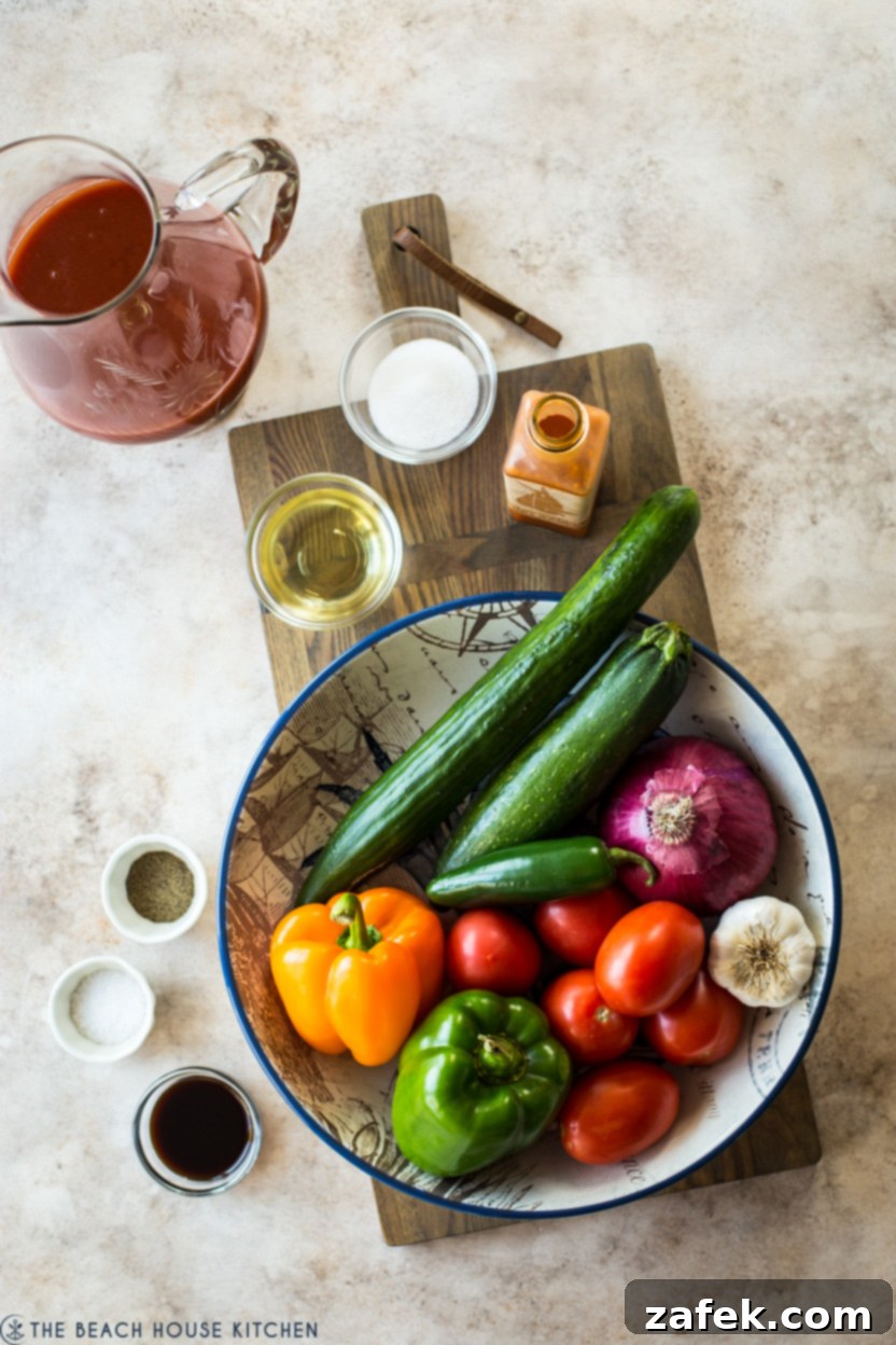 An overhead view of a rustic bowl brimming with colorful, chopped vegetables for gazpacho.