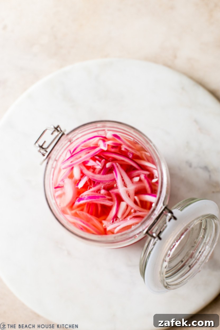 Overhead photo of a jar of vibrant pickled red onions, ready to eat