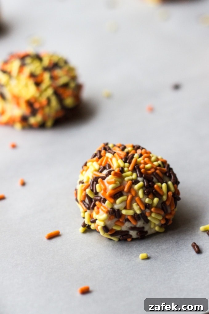 Two plates stacked, holding an abundance of Classic Sprinkled Sugar Cookies, glistening with colorful sprinkles.