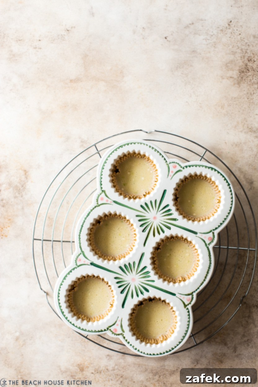 An overhead view of a cupcake pan filled with unbaked margarita cupcake batter, ready for the oven
