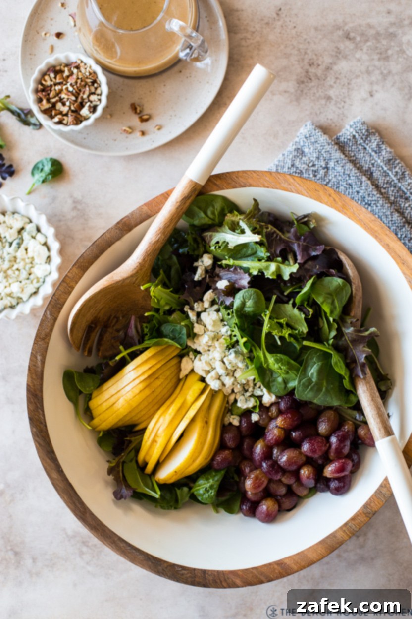 Maple Drizzled Roasted Grape Pear Blue Cheese Salad 2 Overhead photo of a vibrant Roasted Grape Salad with Pears, Blue Cheese and Maple Dressing, showcasing fresh greens, ruby-red grapes, golden pear slices, and crumbled blue cheese, all drizzled with a rich maple dressing.
