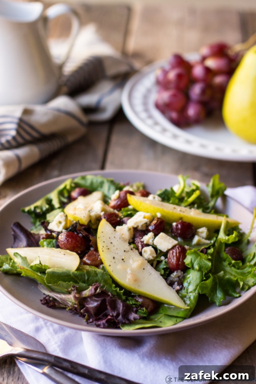 Maple Drizzled Roasted Grape Pear Blue Cheese Salad 6 A stunning close-up of a plated Roasted Grape Salad with Pears, Blue Cheese and Maple Dressing, showcasing the vibrant greens, caramelized grapes, pear slices, and generous blue cheese crumbles, ready to be enjoyed.