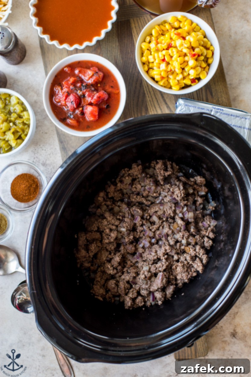 Overhead photo a a slow cooker filled with cooked ground beef and onions