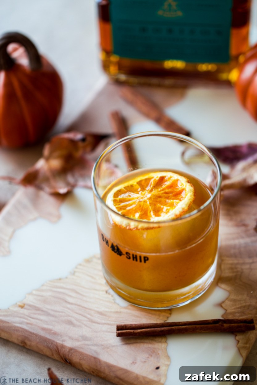 Fireside Pumpkin Old Fashioned 7 An inviting, up-close photo of a Pumpkin Spice Old Fashioned cocktail, showcasing its rich color and elegant garnish, ready to be enjoyed.