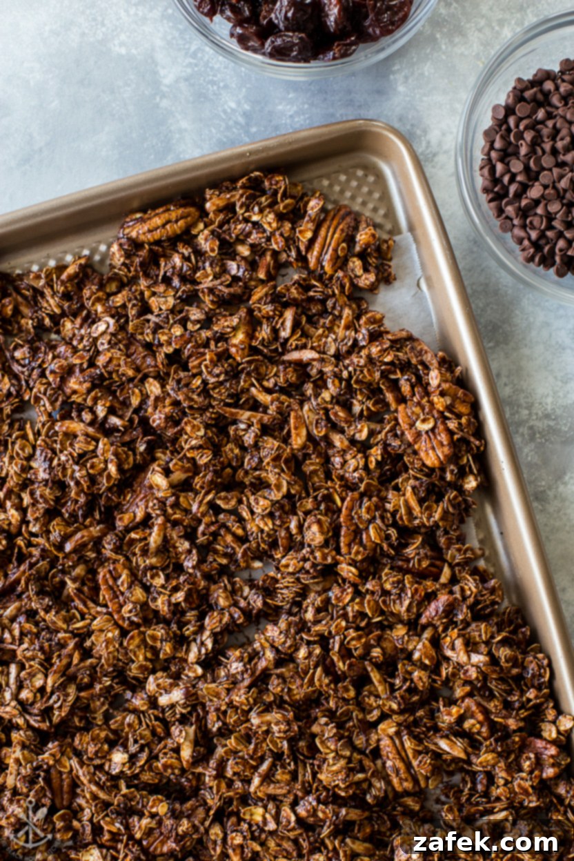 Cherry Chocolate Crunch 2 Up close overhead photo of a tray of chocolate cherry granola, highlighting its rich texture and chunks