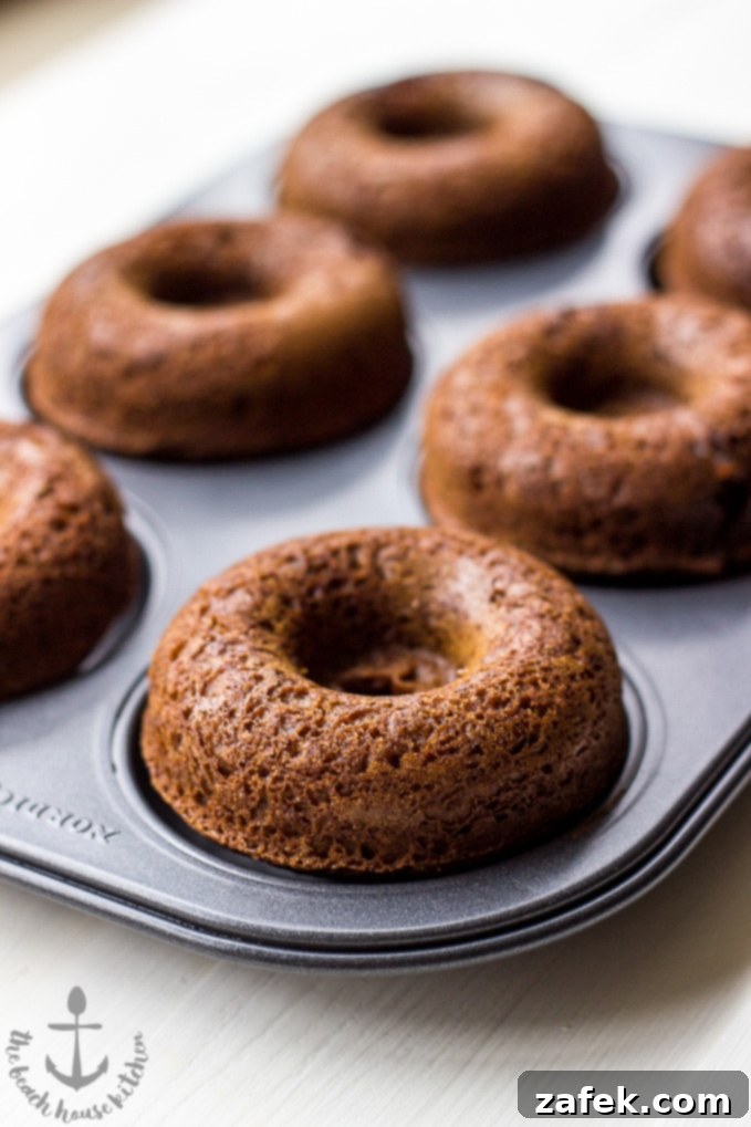 Gingerbread Donut Bliss 5 Three gingerbread donuts on a wire rack, freshly glazed and cooling, with sprinkles