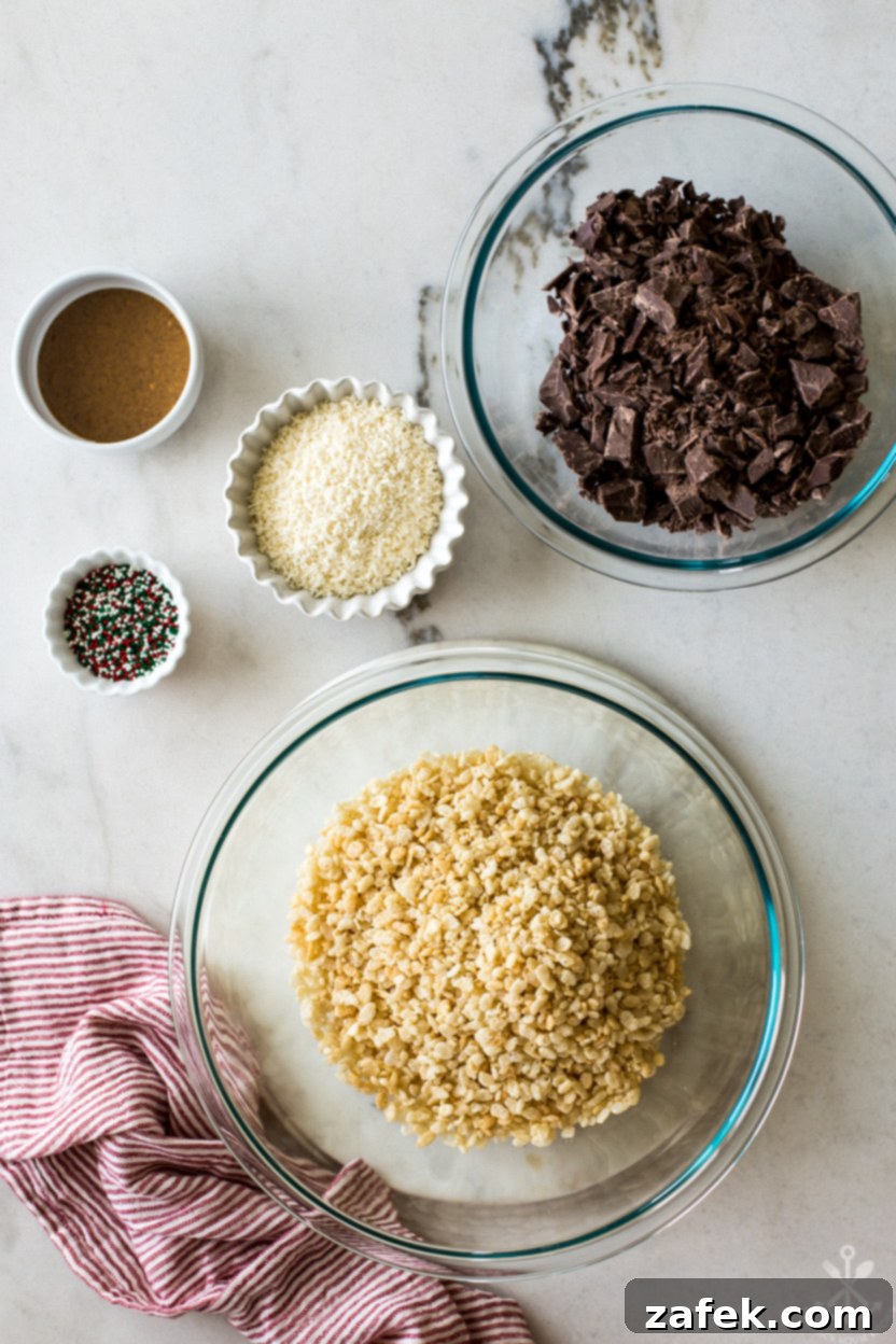 Overhead photo of key ingredients for crispy rice cereal candy cups, meticulously arranged on a rustic surface, including chocolate almond bark, puffed rice cereal, unsweetened shredded coconut, and a jar of crunchy almond butter