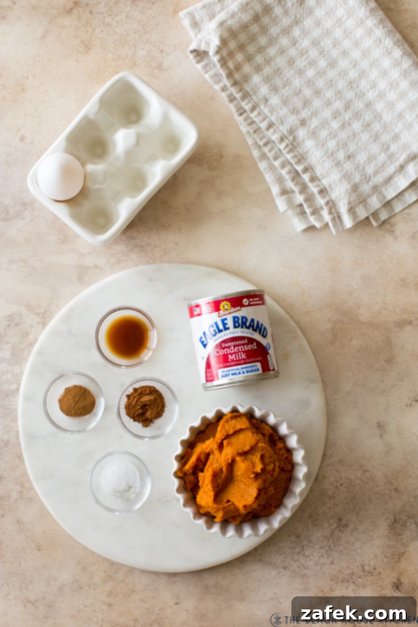 Overhead photo of ingredients for pumpkin pies on a round marble board