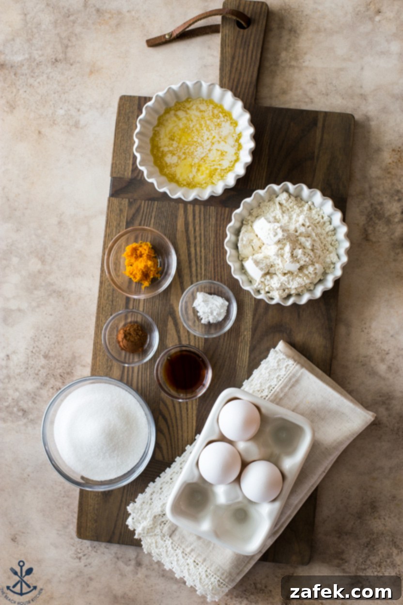 Overhead photo of essential ingredients for madeleine cookies laid out on a clean surface.