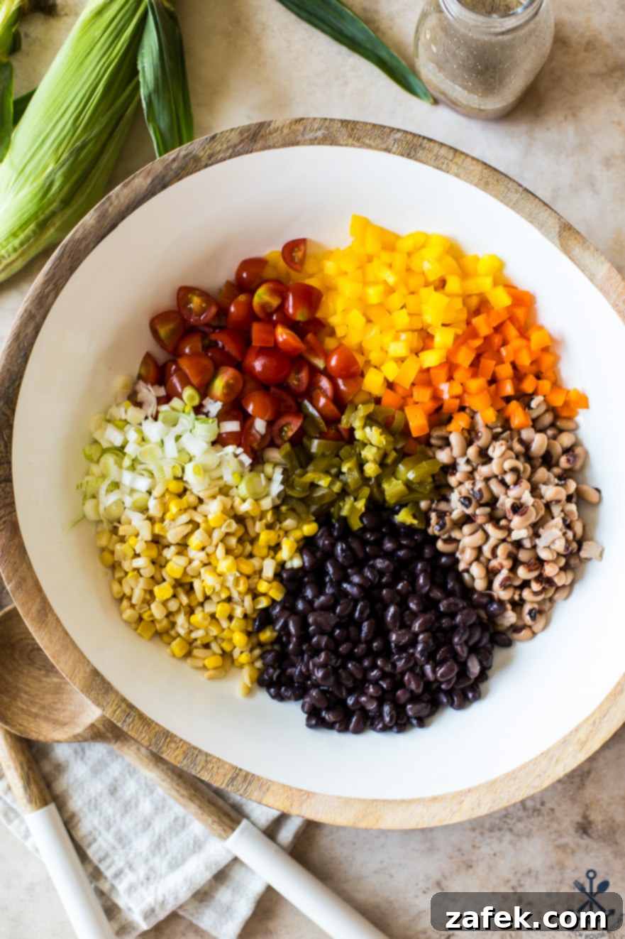 Lone Star Fiesta Salad 3 A collection of fresh, colorful vegetables including corn, peppers, and tomatoes, neatly arranged in a white bowl, poised for transformation into delicious Texas Caviar.