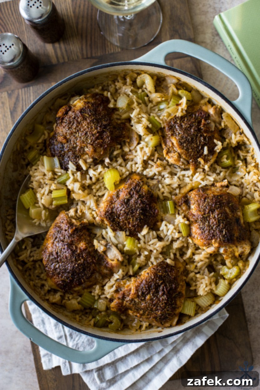 A Taste of Home: Mum's Chicken and Rice 2 Overhead photo of a skillet of Mum's Chicken and Rice, featuring golden-brown chicken thighs nestled in aromatic rice with visible celery and onion chunks, ready to be served.
