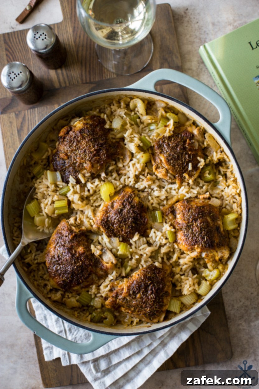 A Taste of Home: Mum's Chicken and Rice 3 Overhead photo of a large round skillet filled with Mum's Chicken and Rice, showcasing perfectly cooked chicken thighs atop a rich, golden rice base infused with herbs and vegetables.