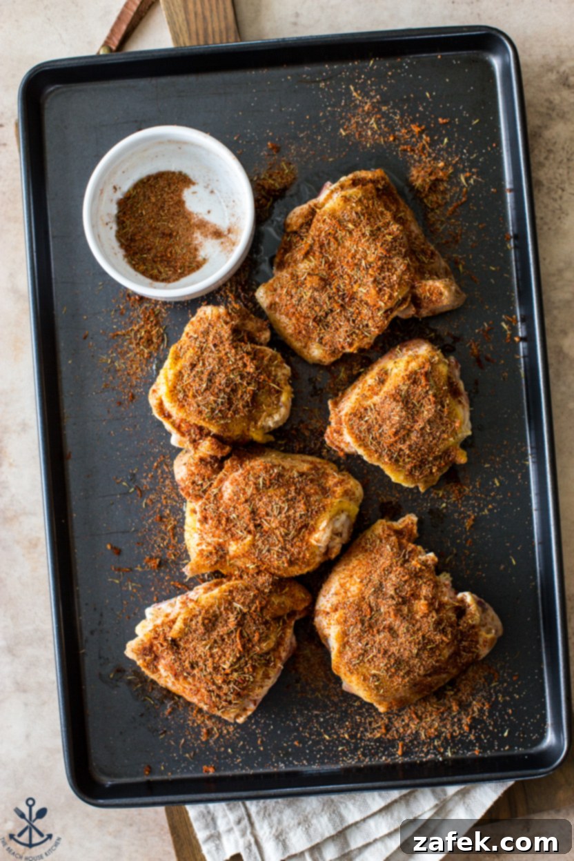 A Taste of Home: Mum's Chicken and Rice 7 Overhead photo of a baking sheet featuring several pre-cooked, perfectly seared and seasoned chicken thighs with crispy, golden skin, arranged and ready to be combined with rice for baking.