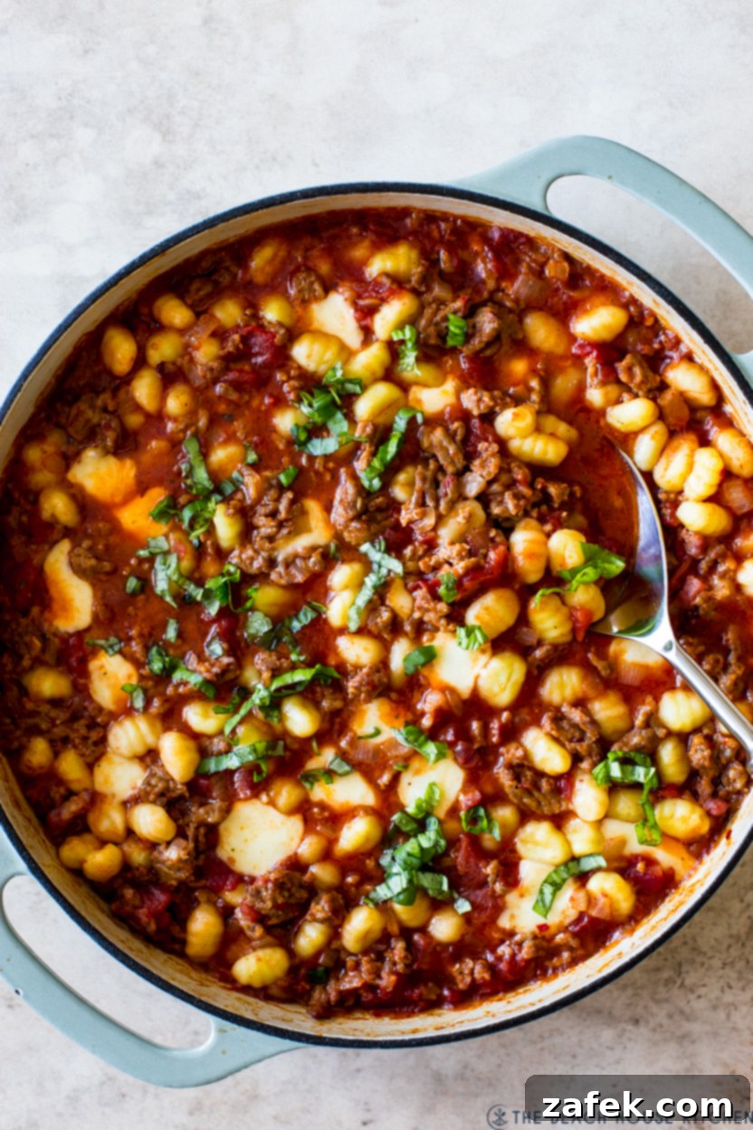 Overhead photo of a skillet of pasta and Italian sausage in a red sauce, ready to be served.