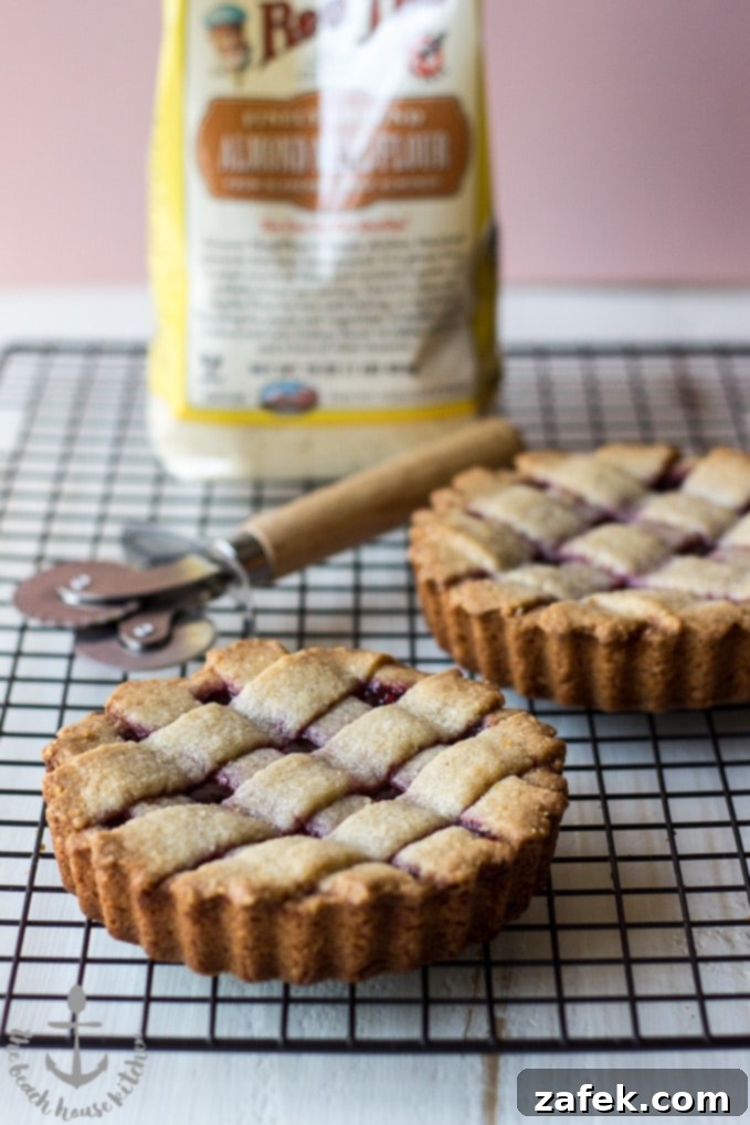 Miniature Linzer Torte set on a rustic wooden surface, showcasing its vibrant color.