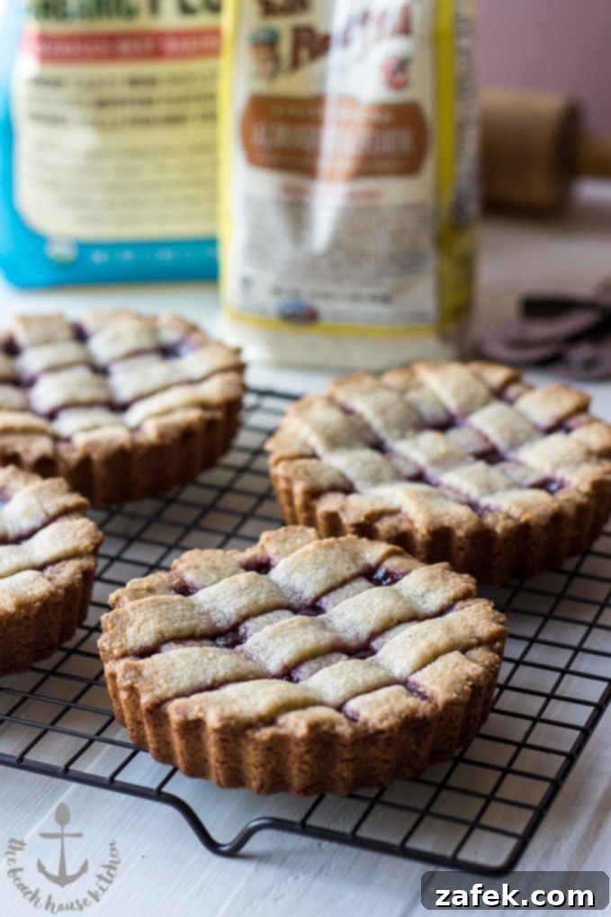 A side view of a Miniature Linzer Torte, highlighting the thickness of the crust and jam.