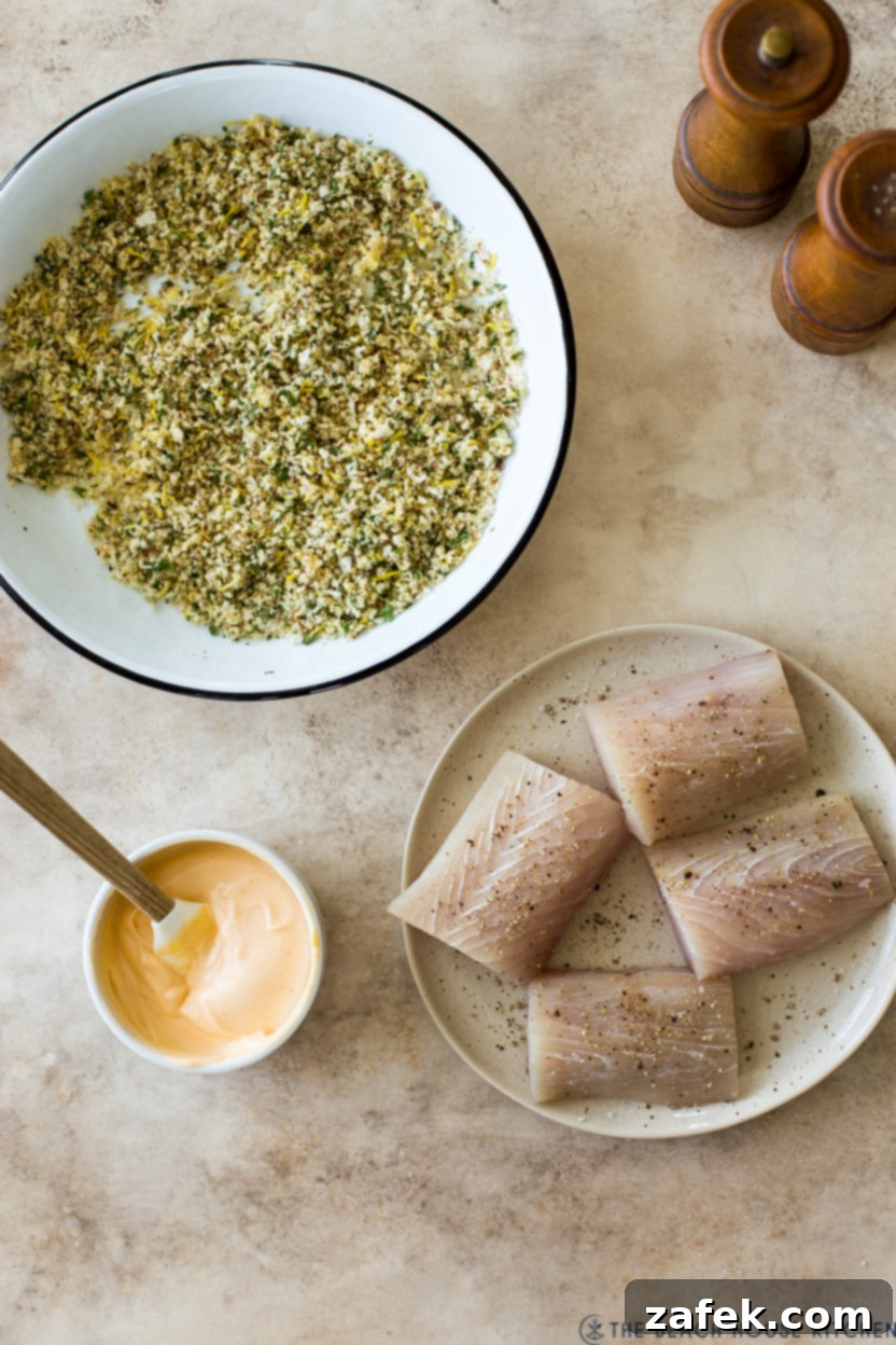 Effortless Sheet Pan Mahi Mahi with Crispy Potatoes and Asparagus 5 Overhead photo of a plate of fish fillets, a bowl of seasoned breadcrumbs and a small bowl of spicy mayo.