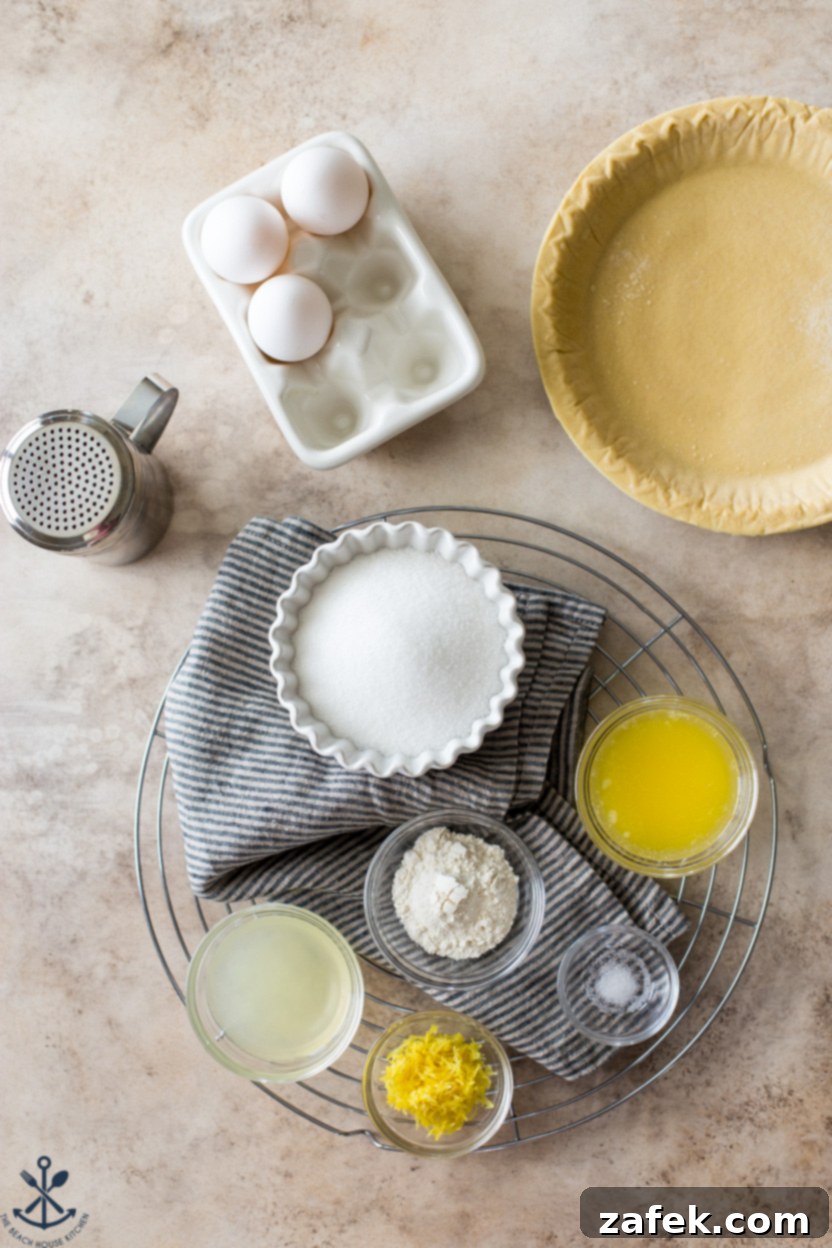 Tangy Lemon Chess Pie 4 Overhead photo showcasing the fresh ingredients laid out for a Lemon Chess Pie, including lemons, eggs, butter, sugar, and flour.