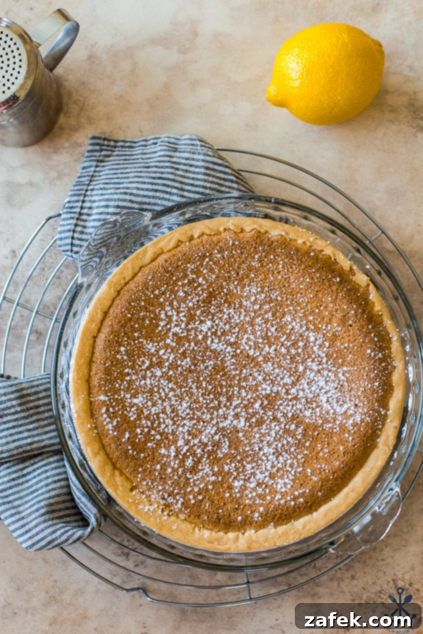 Tangy Lemon Chess Pie 6 Close-up overhead view of a cooled Lemon Chess Pie, showing its glossy, smooth surface and inviting golden hue.
