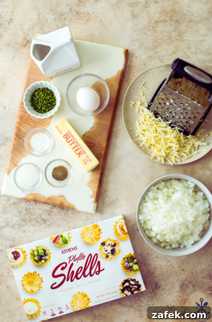 Overhead photo of all the ingredients for French onion soup bites laid out on a kitchen counter, including onions, cheese, butter, and phyllo shells