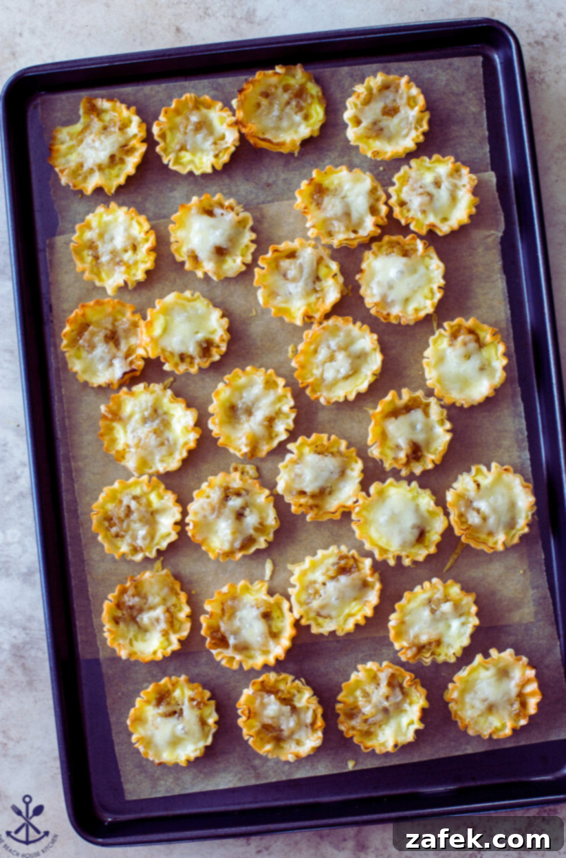 Overhead photo of a baking sheet filled with freshly cooked French Onion Soup Bites, golden and puffy