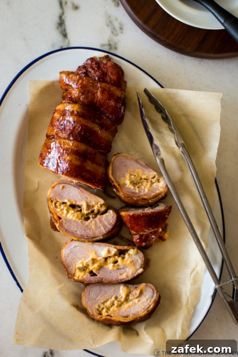 Exquisite Bacon-Wrapped Stuffed Pork Tenderloin 2 Overhead photo of a perfectly cooked bacon wrapped stuffed pork tenderloin, sliced and ready to serve