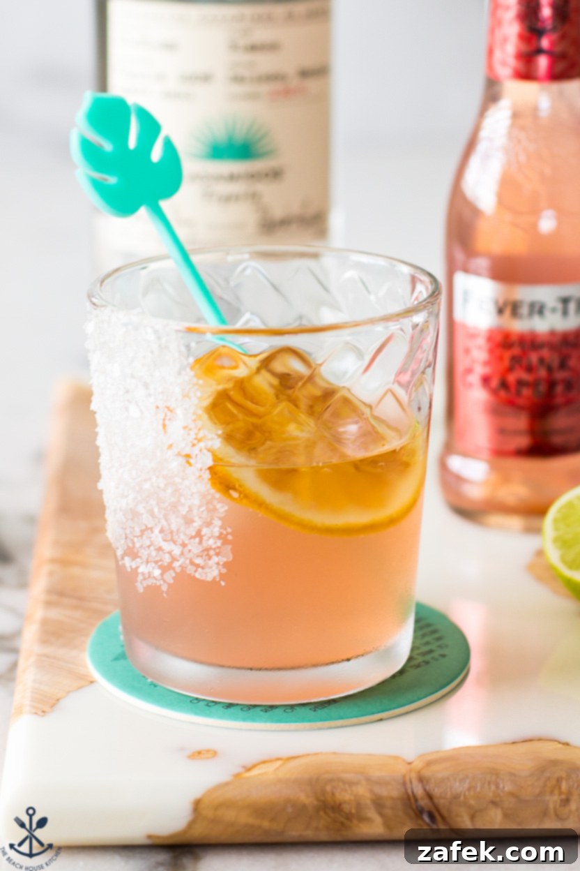 The Perfect Paloma Cocktail 5 Up close photo of a Paloma cocktail with condensation on the glass and a garnish of dehydrated orange.
