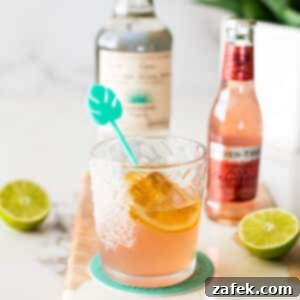 The Perfect Paloma Cocktail 6 Paloma Cocktail served in a glass with a lime wedge and salted rim.