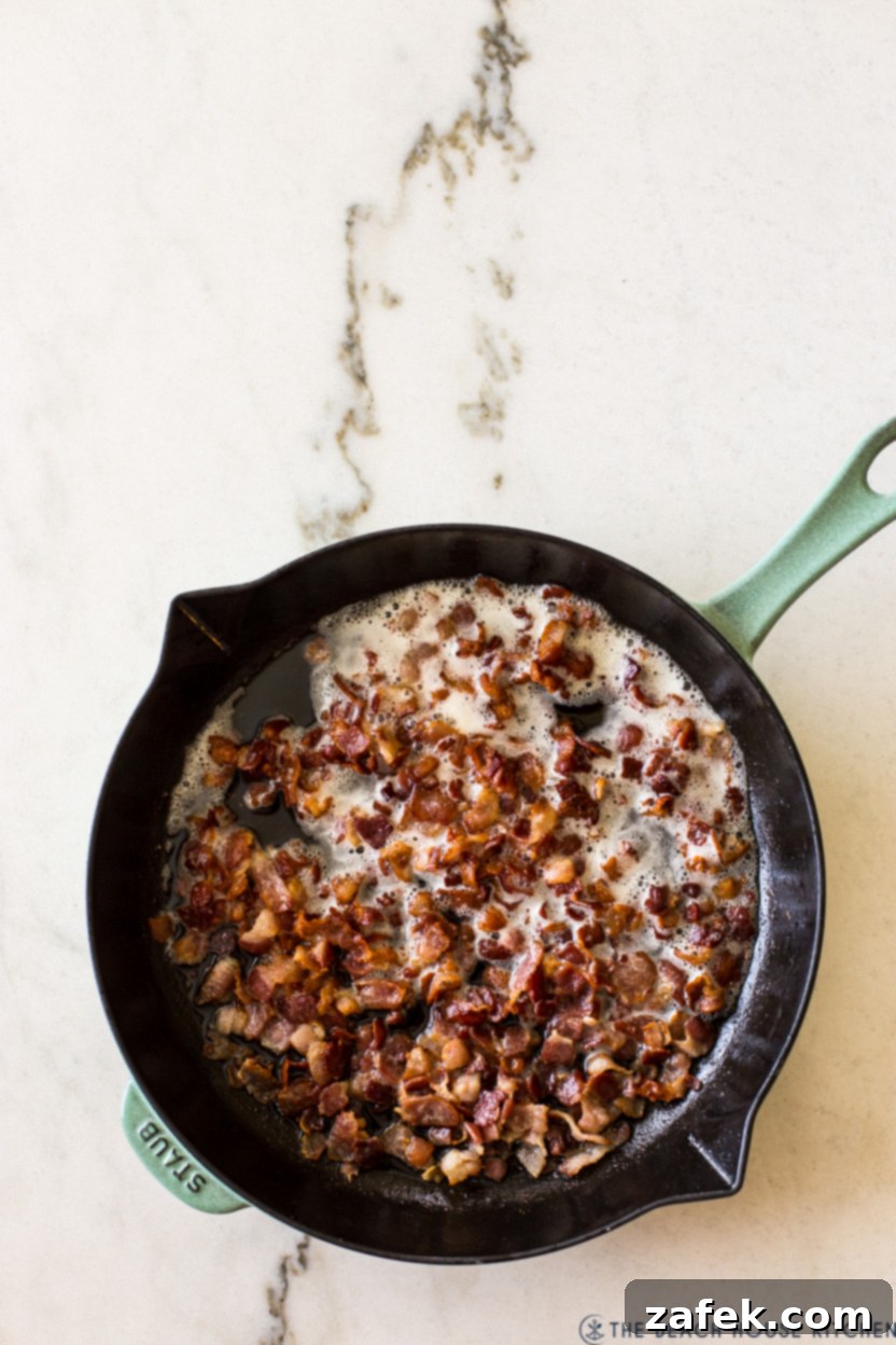 The Ultimate BLT Avocado Pasta Salad 4 Overhead photo of a skillet of cooked diced bacon, crispy and golden