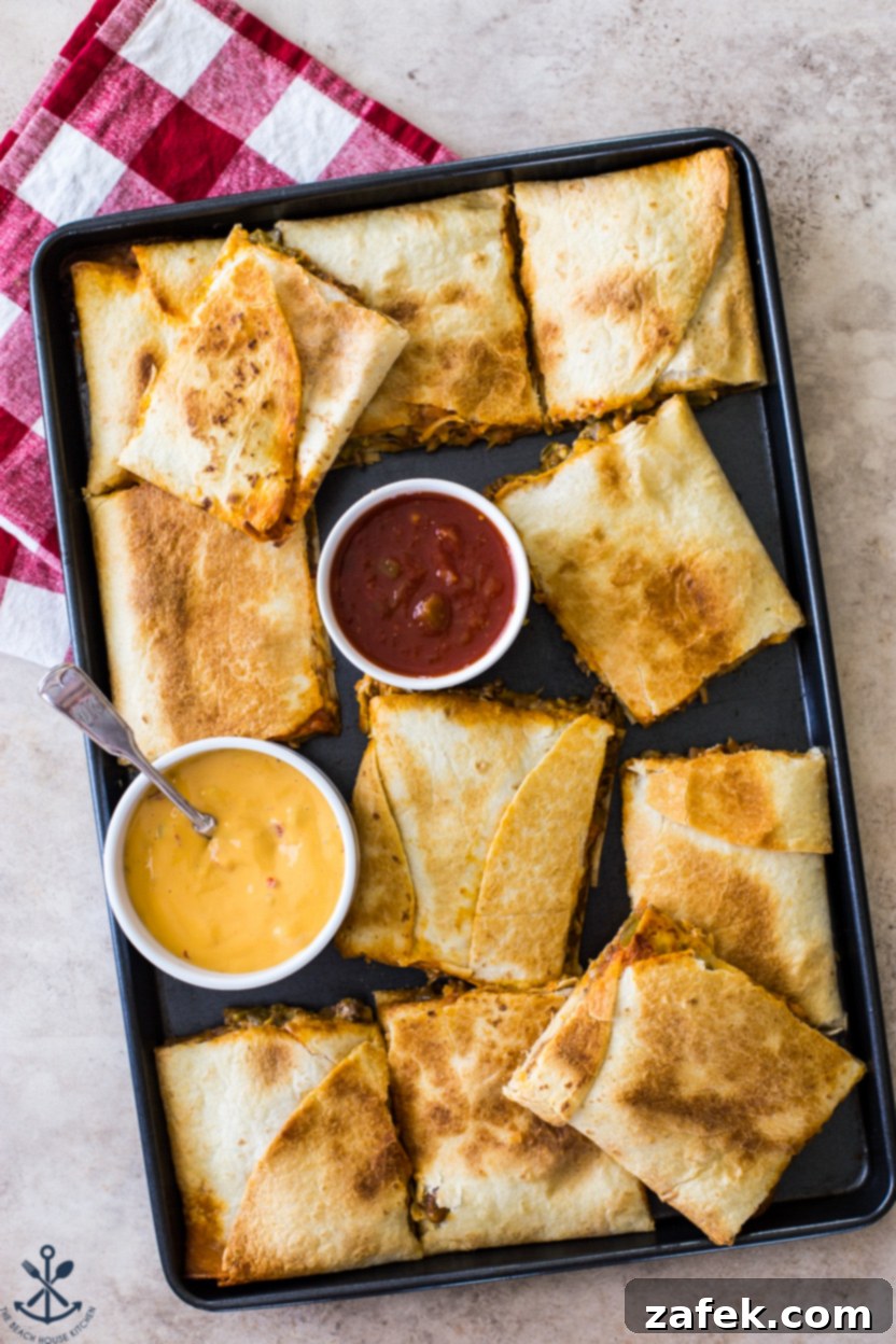 Overhead photo of a sheet pan of beef quesadillas, freshly baked and golden brown with melted cheese