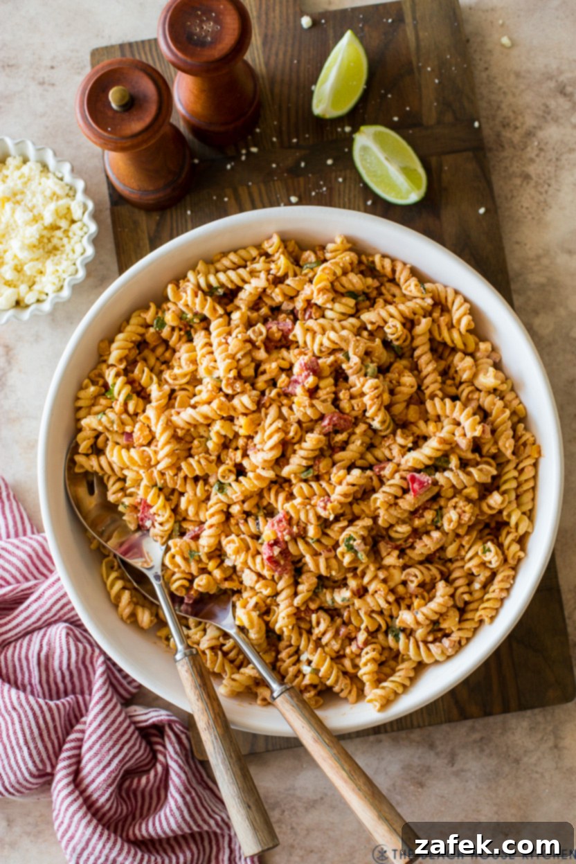 Overhead photo of a bowl of Mexican Street Corn Pasta Salad on a wooden board