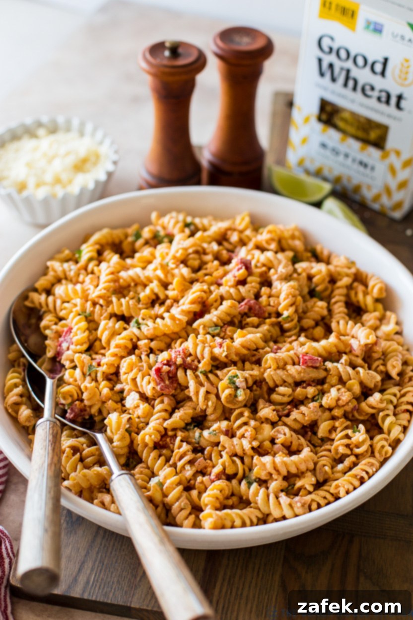Up close photo of a bowl of vibrant Mexican Street Corn Pasta Salad with fresh ingredients visible