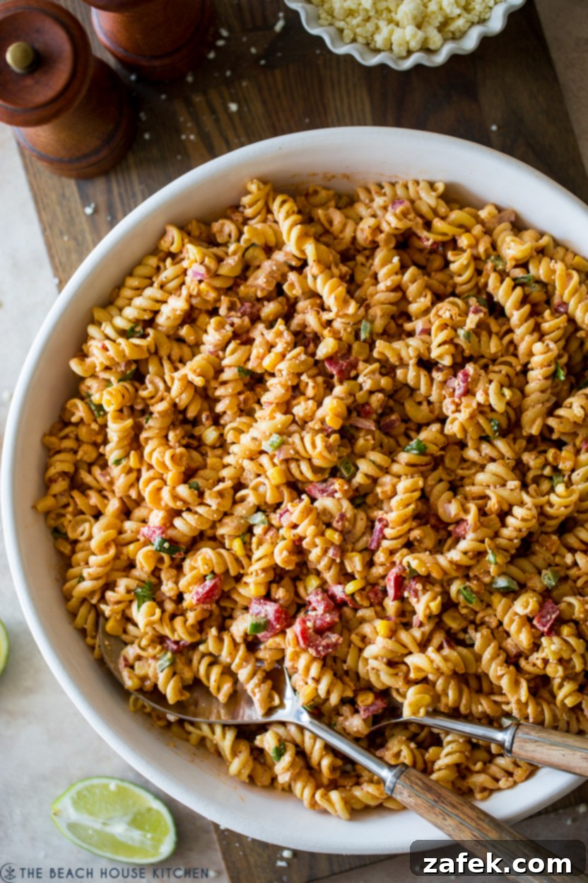 Up close overhead photo of a bowl of Mexican Street Corn Pasta Salad, showing texture and fresh herbs