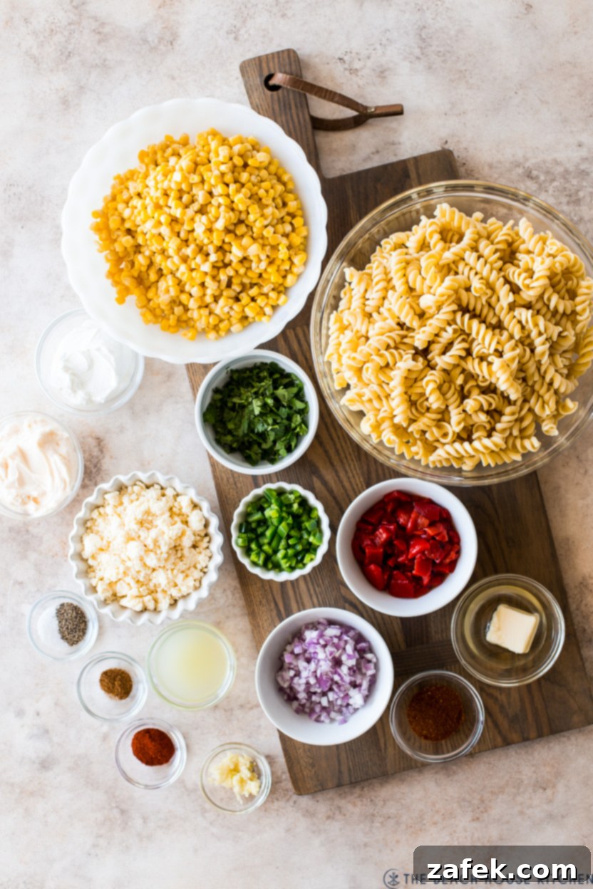 Overhead photo of various fresh ingredients laid out for a pasta salad with corn