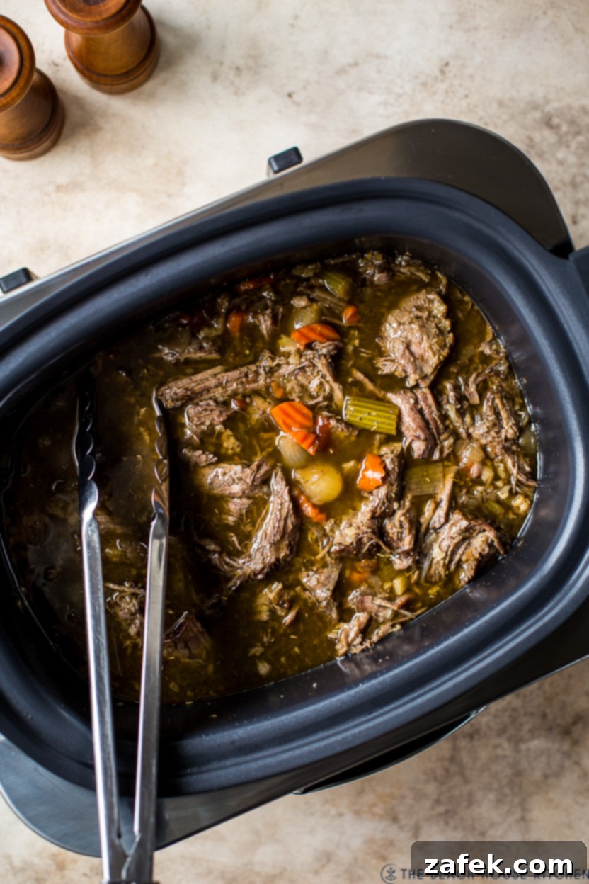 Overhead photo of Italian beef in a slow cooker, showcasing the tender meat and rich sauce