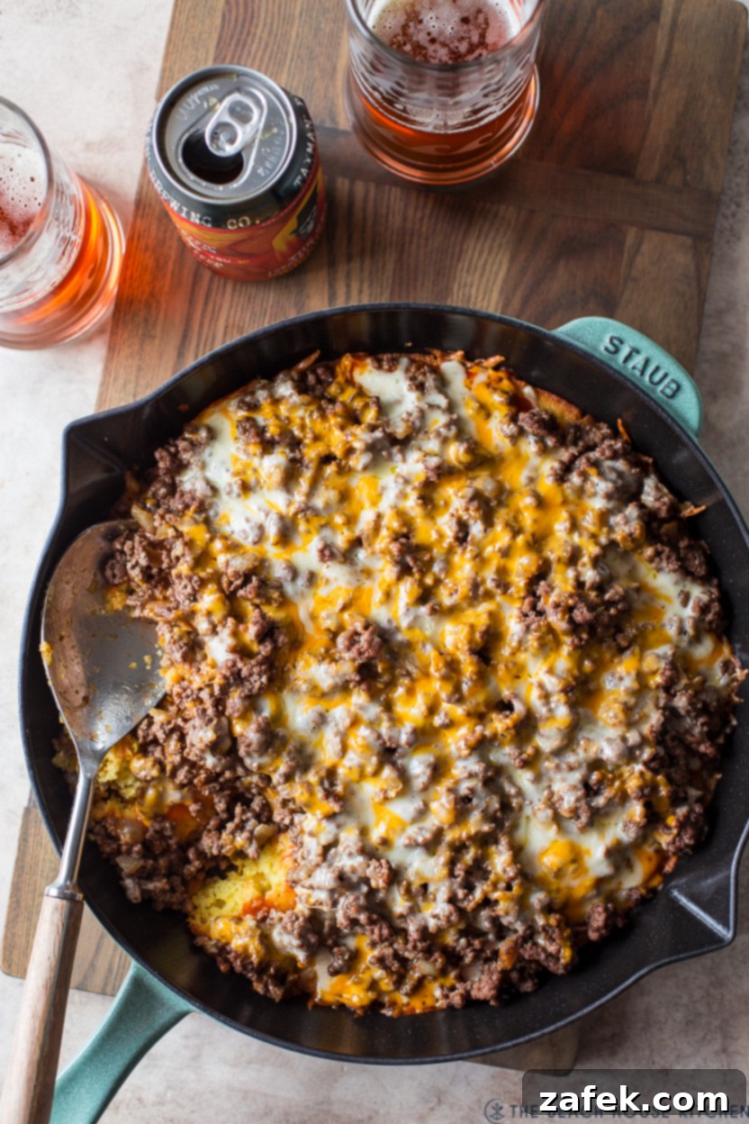 Southwest Tamale Bake 11 Overhead photo of a freshly baked tamale pie in a skillet with a serving spoon, ready to be enjoyed