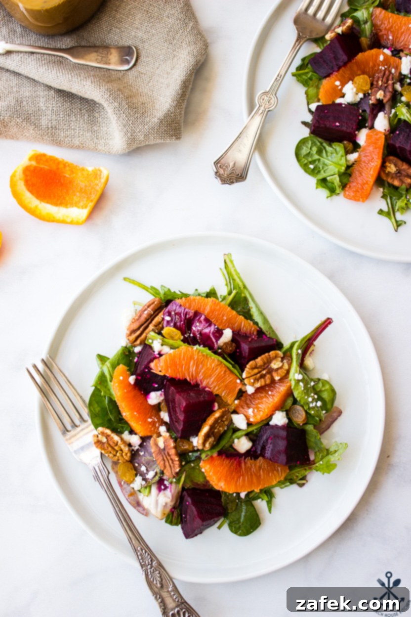 Vibrant Beet and Orange Salad 5 Overhead photo of a salad with beets and oranges on a white plate with a fork