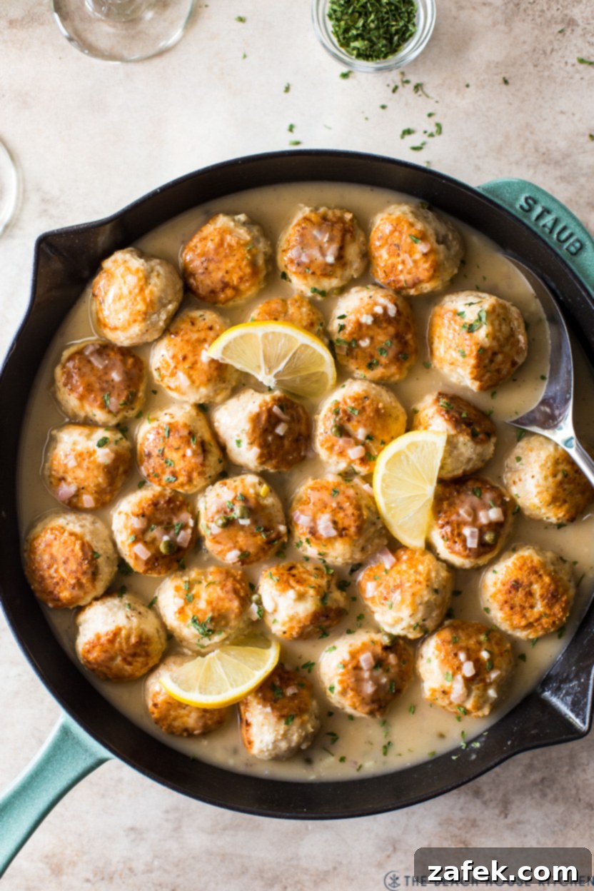 Classic chicken piccata meatballs with a vibrant lemon-caper sauce, garnished with fresh parsley.