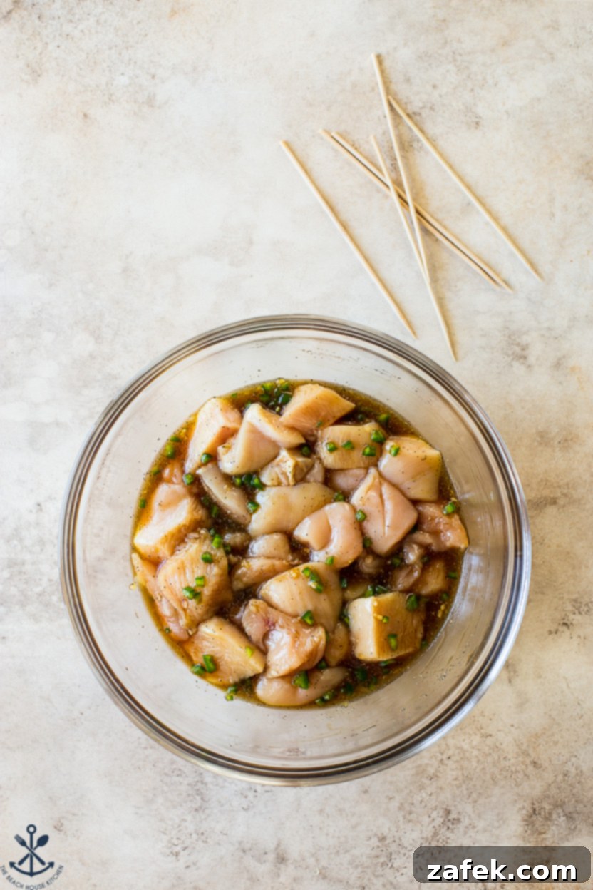 Zesty Sweet Heat Air Fryer Chicken Skewers 5 Overhead photo of a bowl filled with cubed chicken soaking in a vibrant marinade