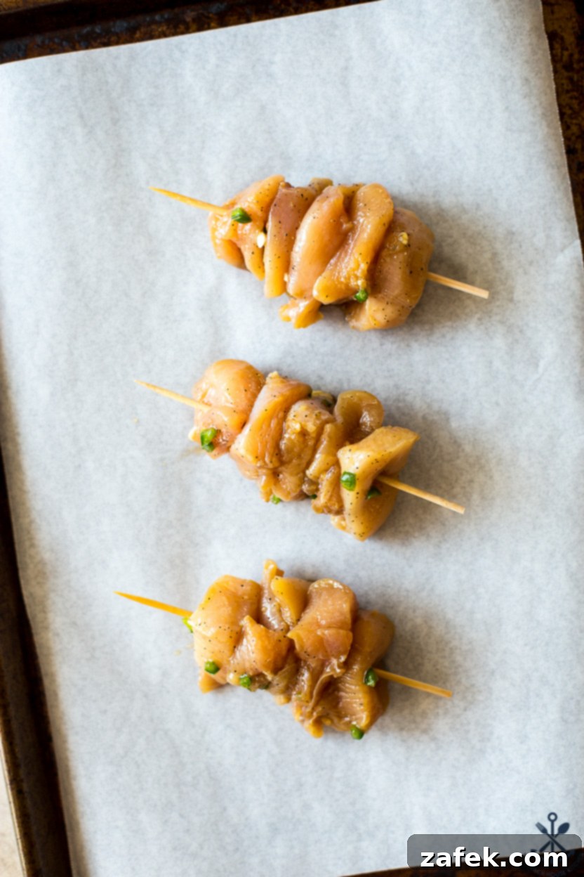 Zesty Sweet Heat Air Fryer Chicken Skewers 6 Overhead photo of uncooked chicken pieces threaded onto wooden skewers, ready for the air fryer