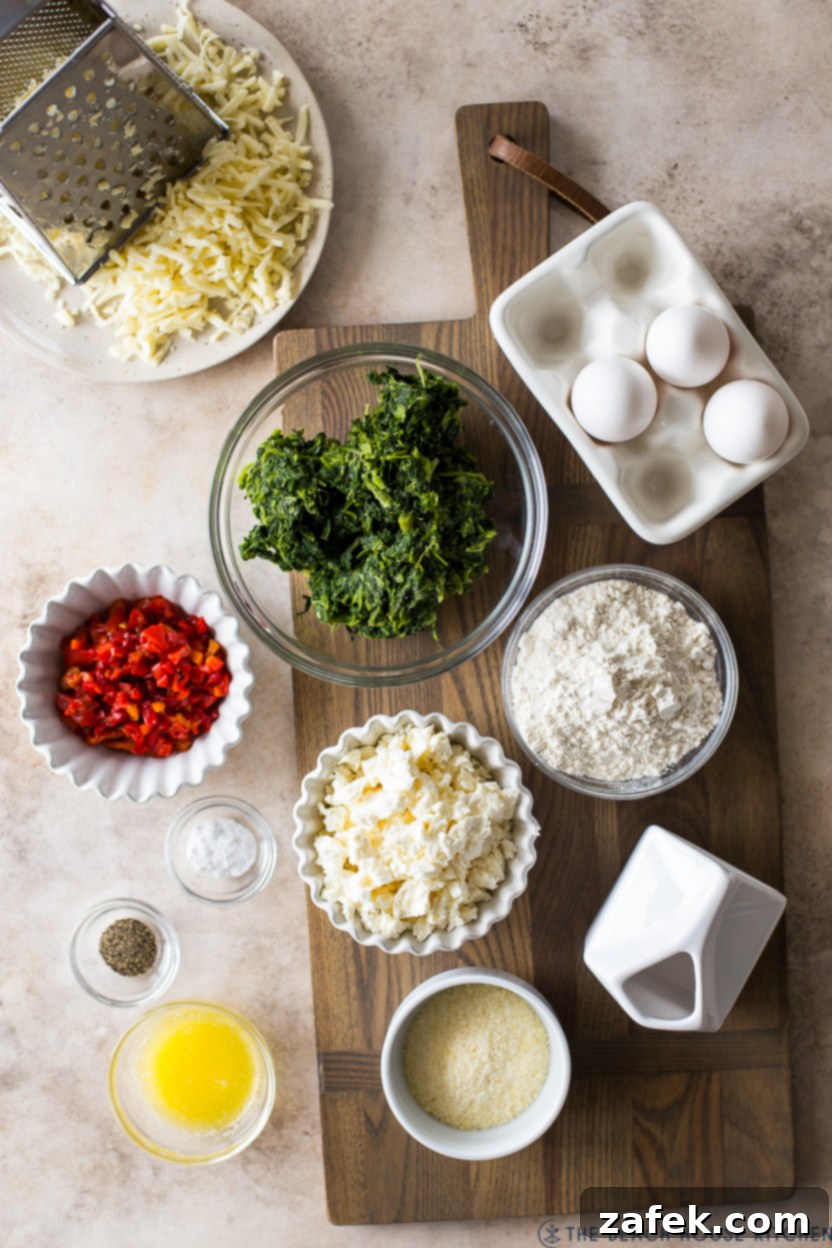 Overhead photo of fresh ingredients for a cheesy Greek spinach egg bake, including eggs, cheese, spinach, and red peppers.