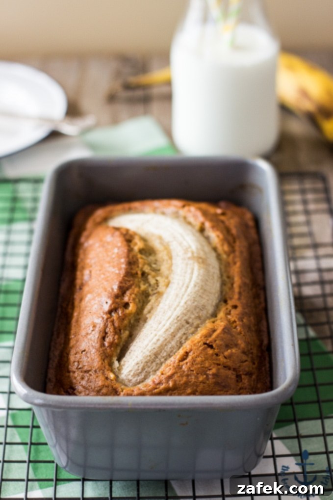 Golden brown butter banana bread loaf on a cooling rack