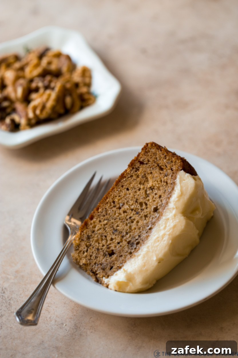 Maple Walnut Cake 2 A slice of Maple Walnut Cake on a white plate with a fork