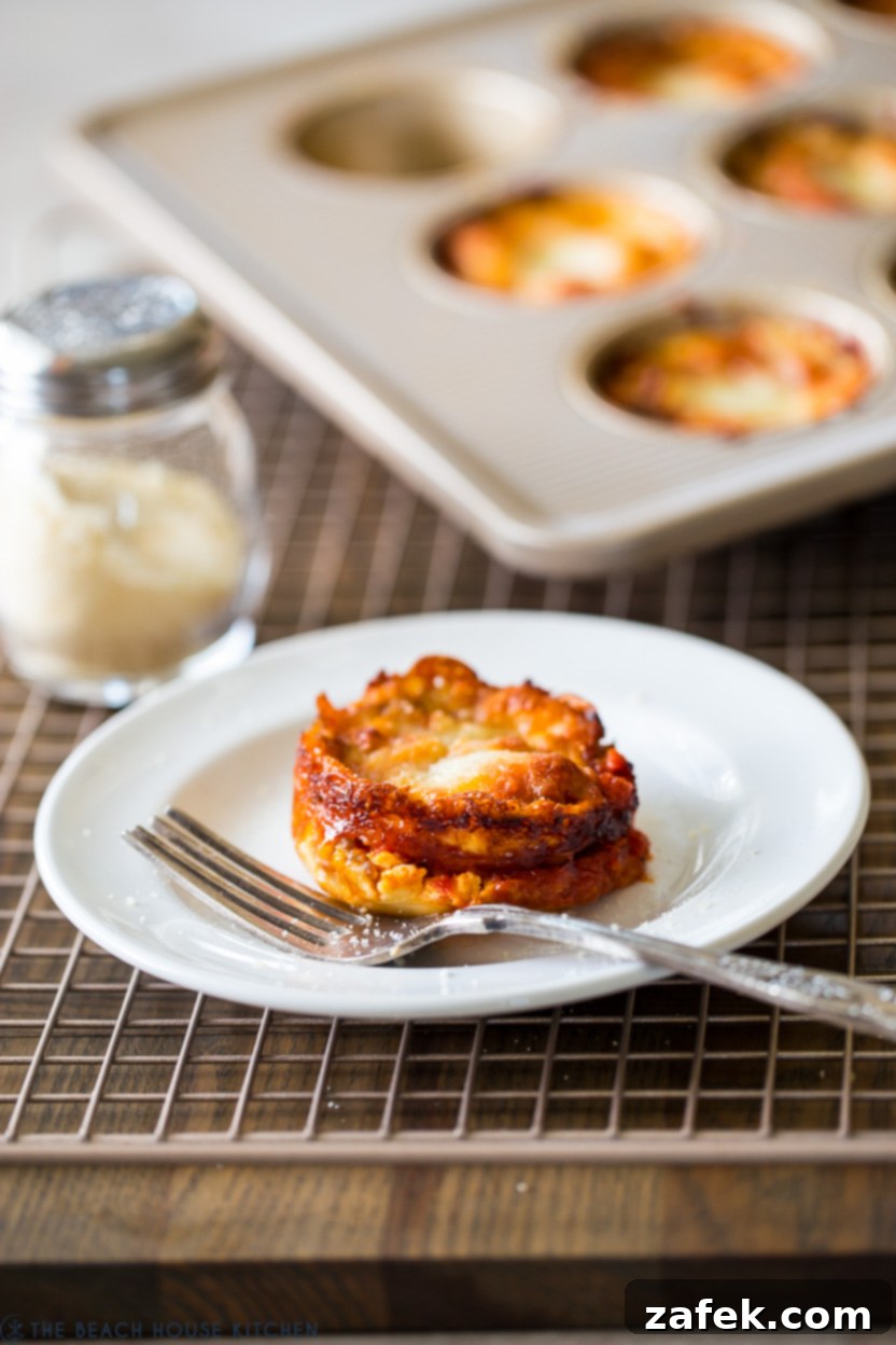 A lasagna cup on a white plate with a fork