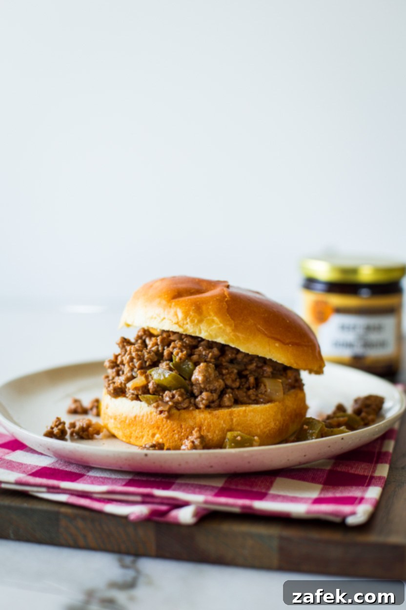 A perfectly prepared Philly Cheesesteak Sloppy Joe served on a bun on a plate, garnished and ready to eat
