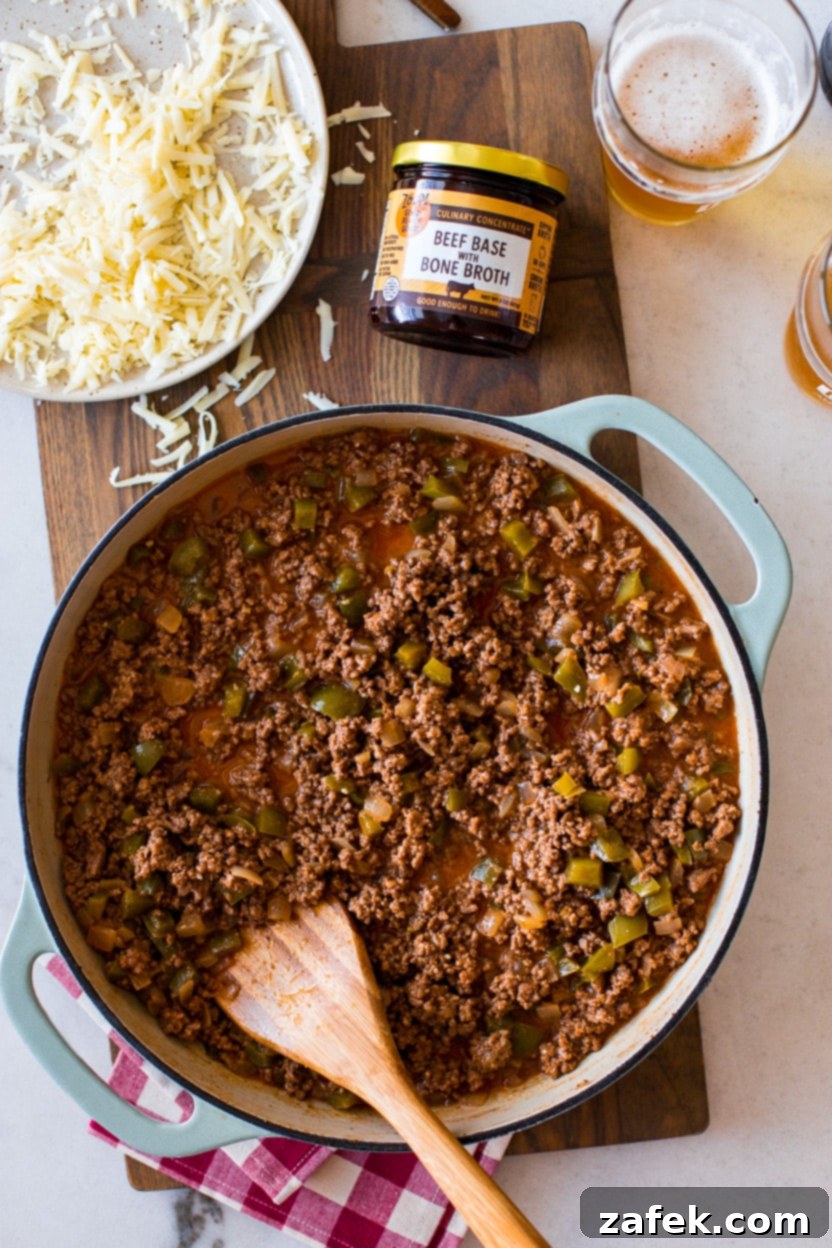 Close-up of the delicious Philly Cheesesteak Sloppy Joe mixture simmering in a skillet, showcasing the rich sauce and tender ingredients