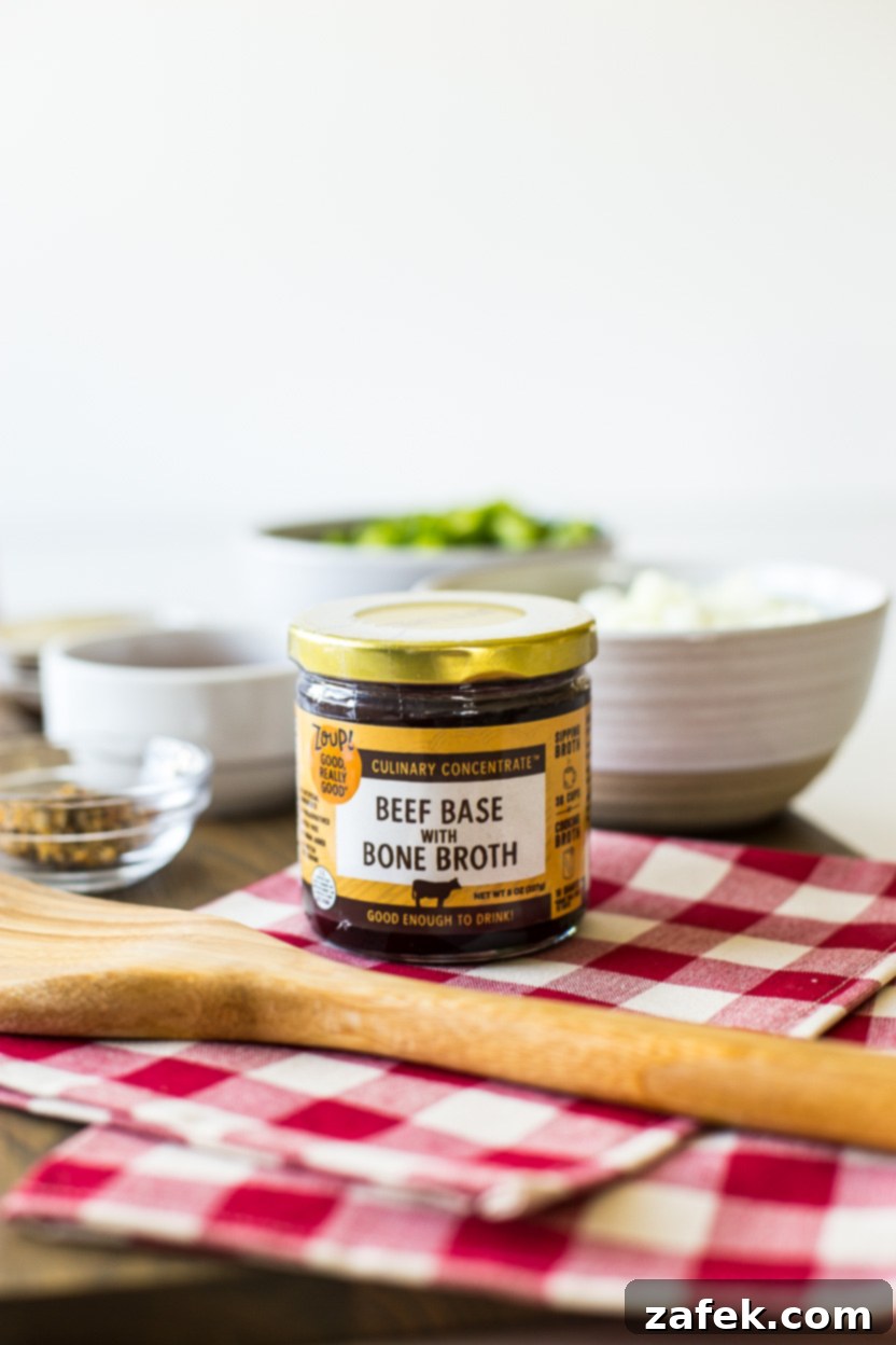 A close-up photo of a Zoup! Good, Really Good® Culinary Concentrate Beef Base with Bone Broth jar, highlighting its premium quality, placed on a red and white checkered napkin